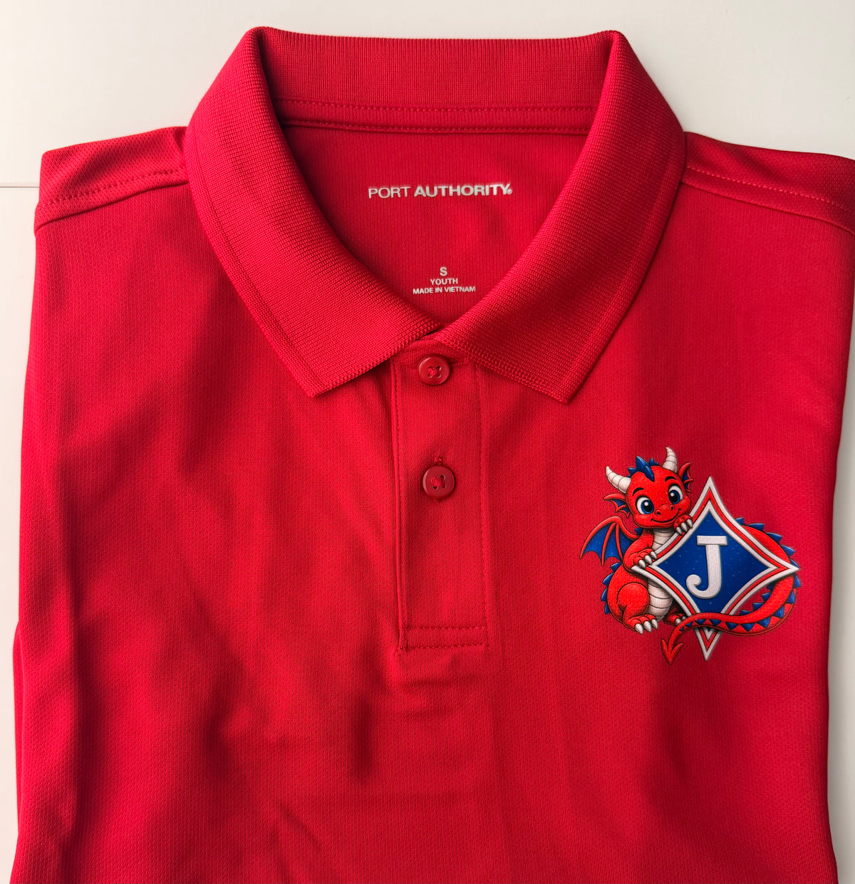 Youth Short Sleeve Moisture Wicking Polo with DTF print of Cute Dragon and Logo