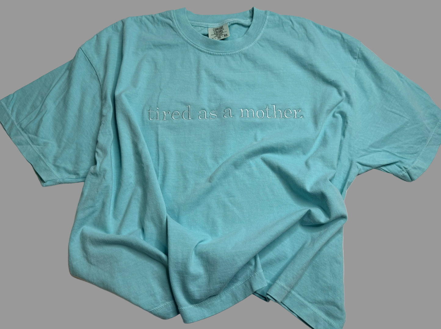 Light blue t-shirt with text on a gray background