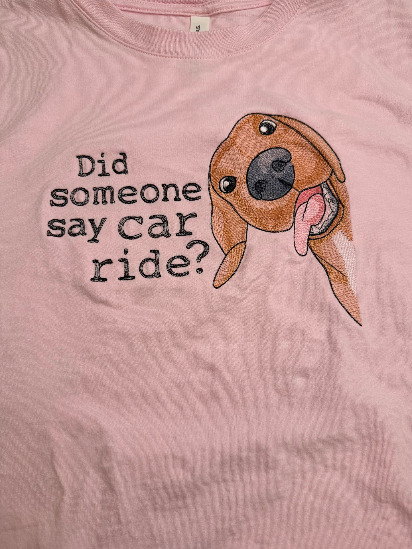 Pink t-shirt with a dog graphic and text 'Did someone say car ride?'