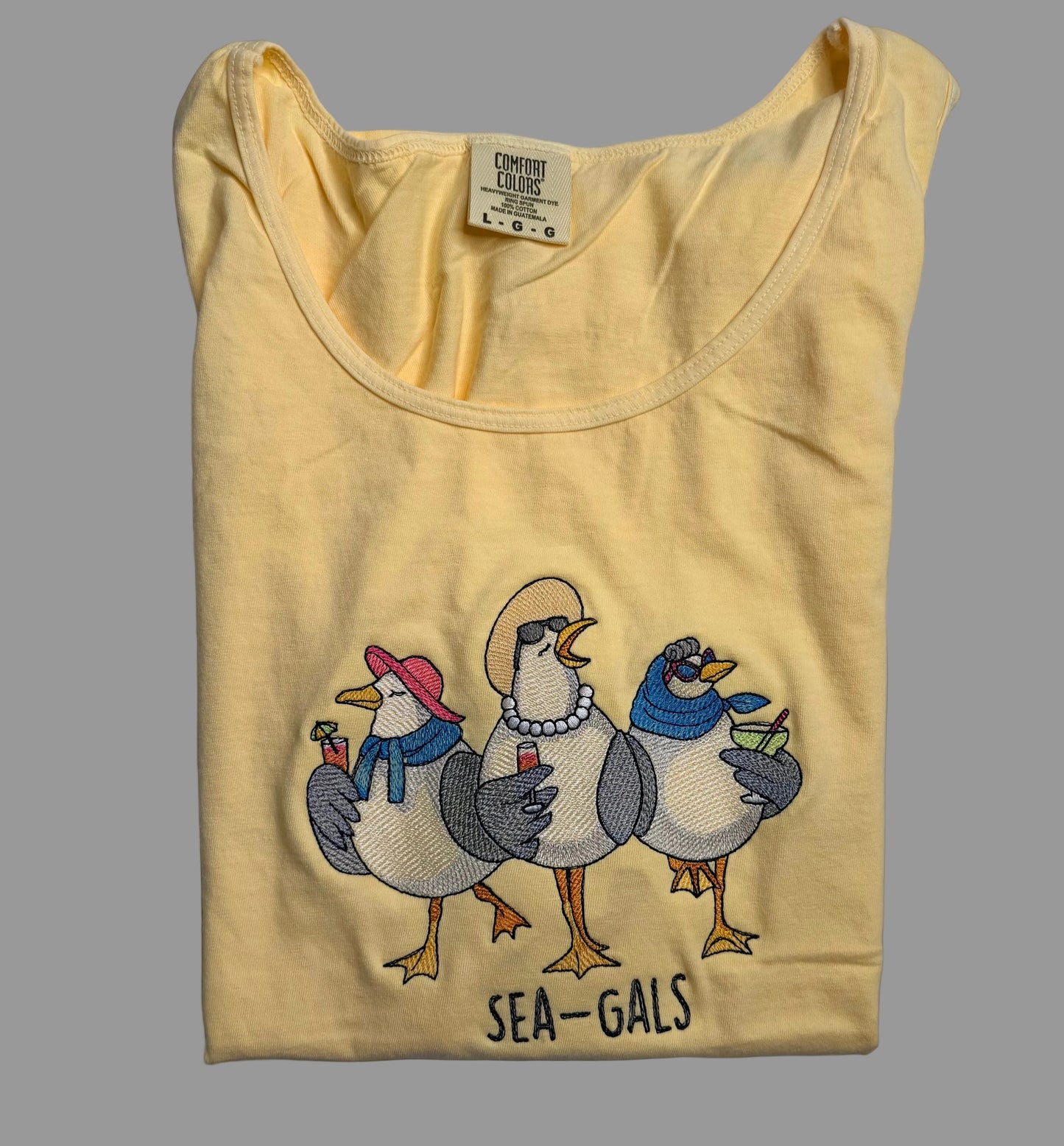 Yellow tank top with 'Sea-Gals' design on a gray background