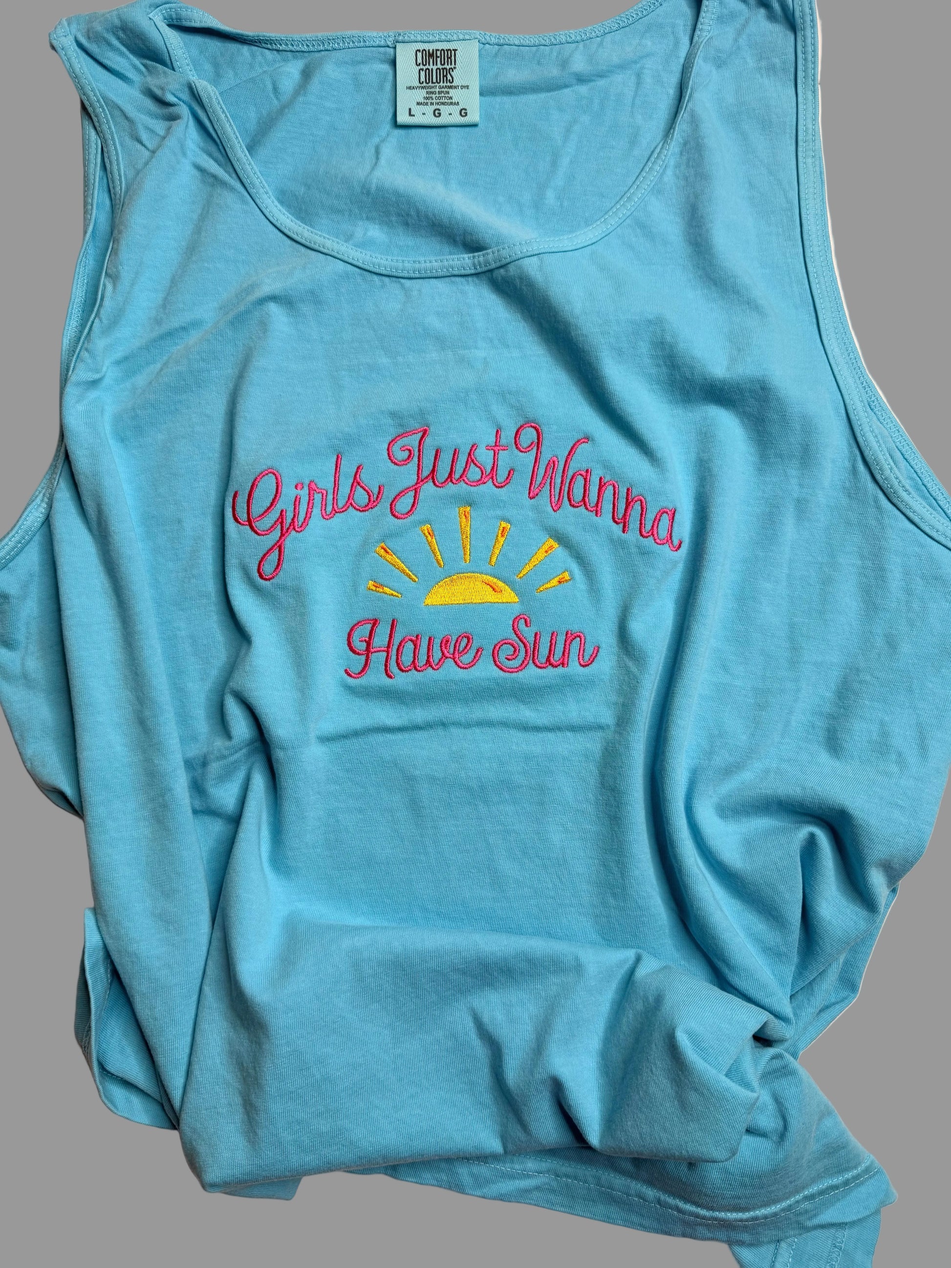 Blue tank top with 'Girls Just Wanna Have Sun' text on a gray background