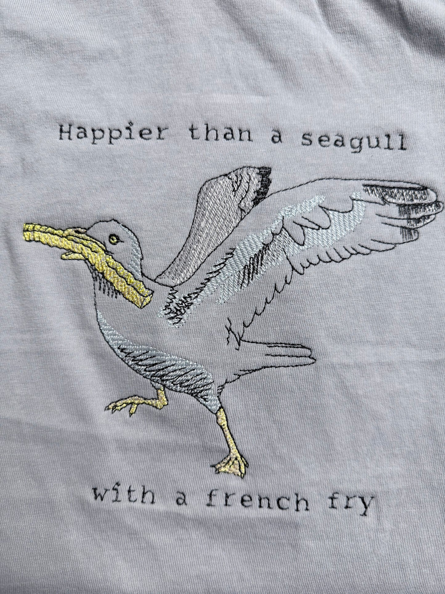 Embroidered seagull with text on a gray fabric background