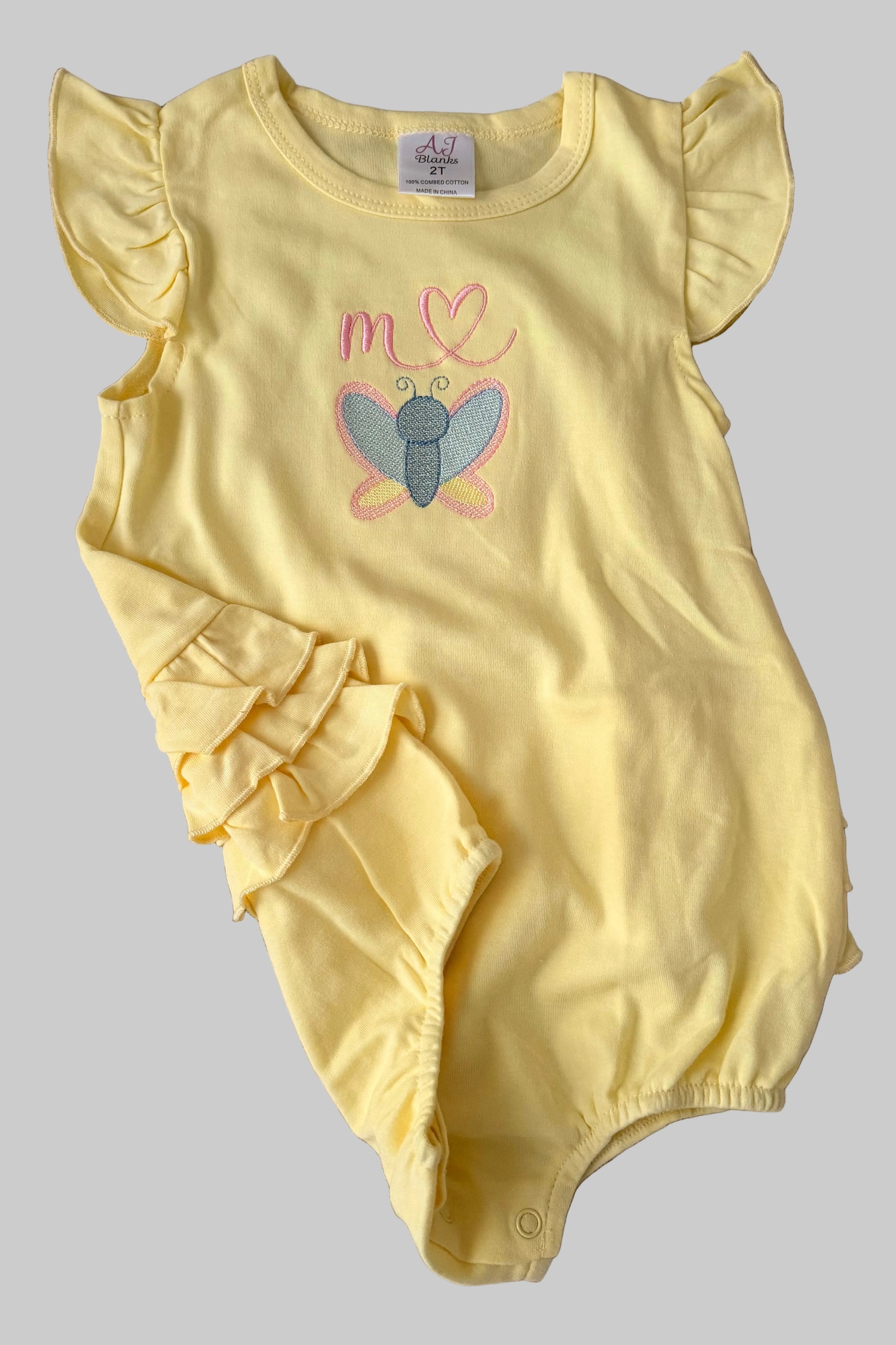 Yellow baby romper with butterfly design on a white background