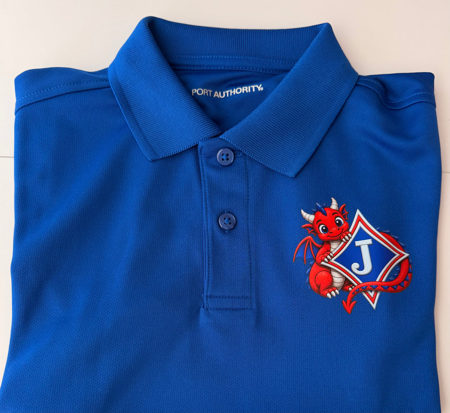 Youth Short Sleeve Moisture Wicking Polo with DTF print of Cute Dragon and Logo