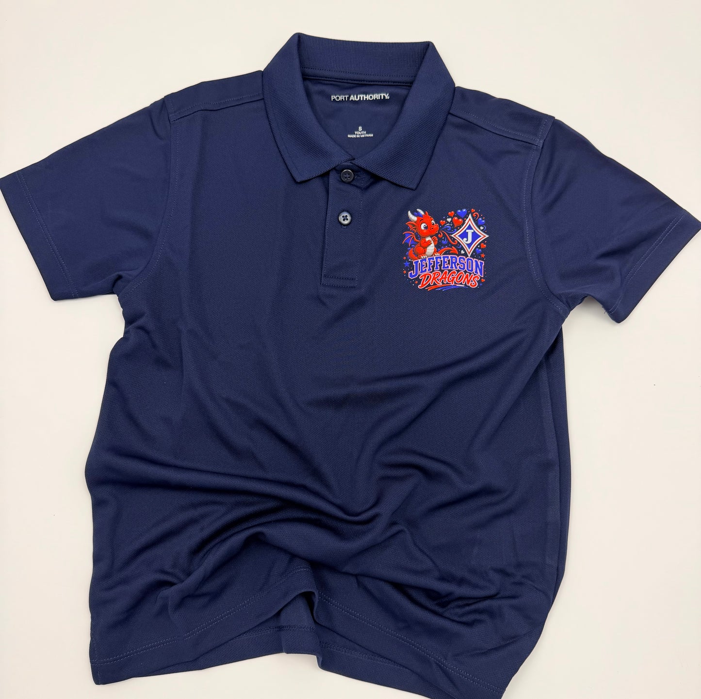 Youth Moisture Wicking Polo with DTF print of cute Dragon Blowing Hearts and the Jefferson Logo