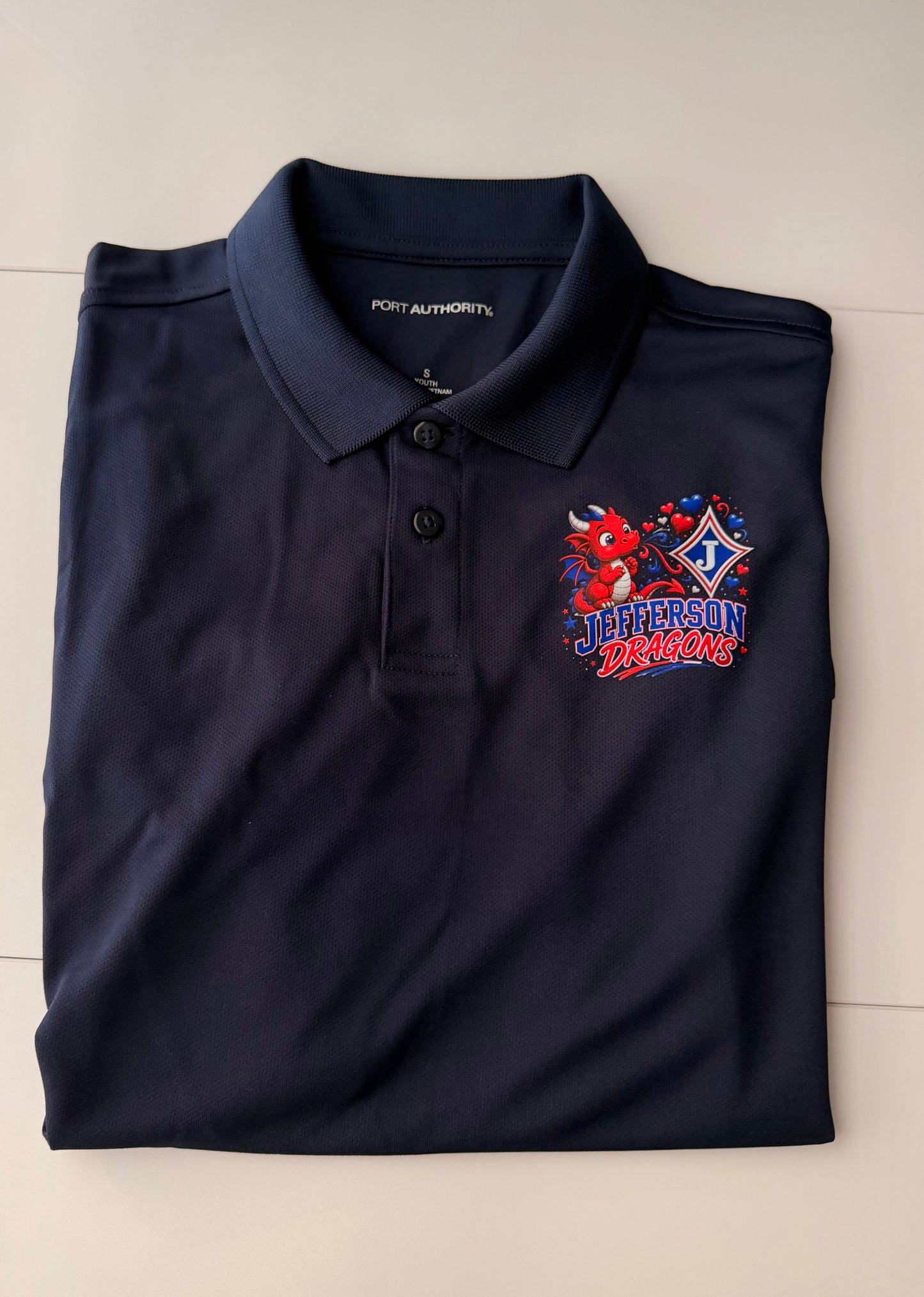 Youth Moisture Wicking Polo with DTF print of cute Dragon Blowing Hearts and the Jefferson Logo