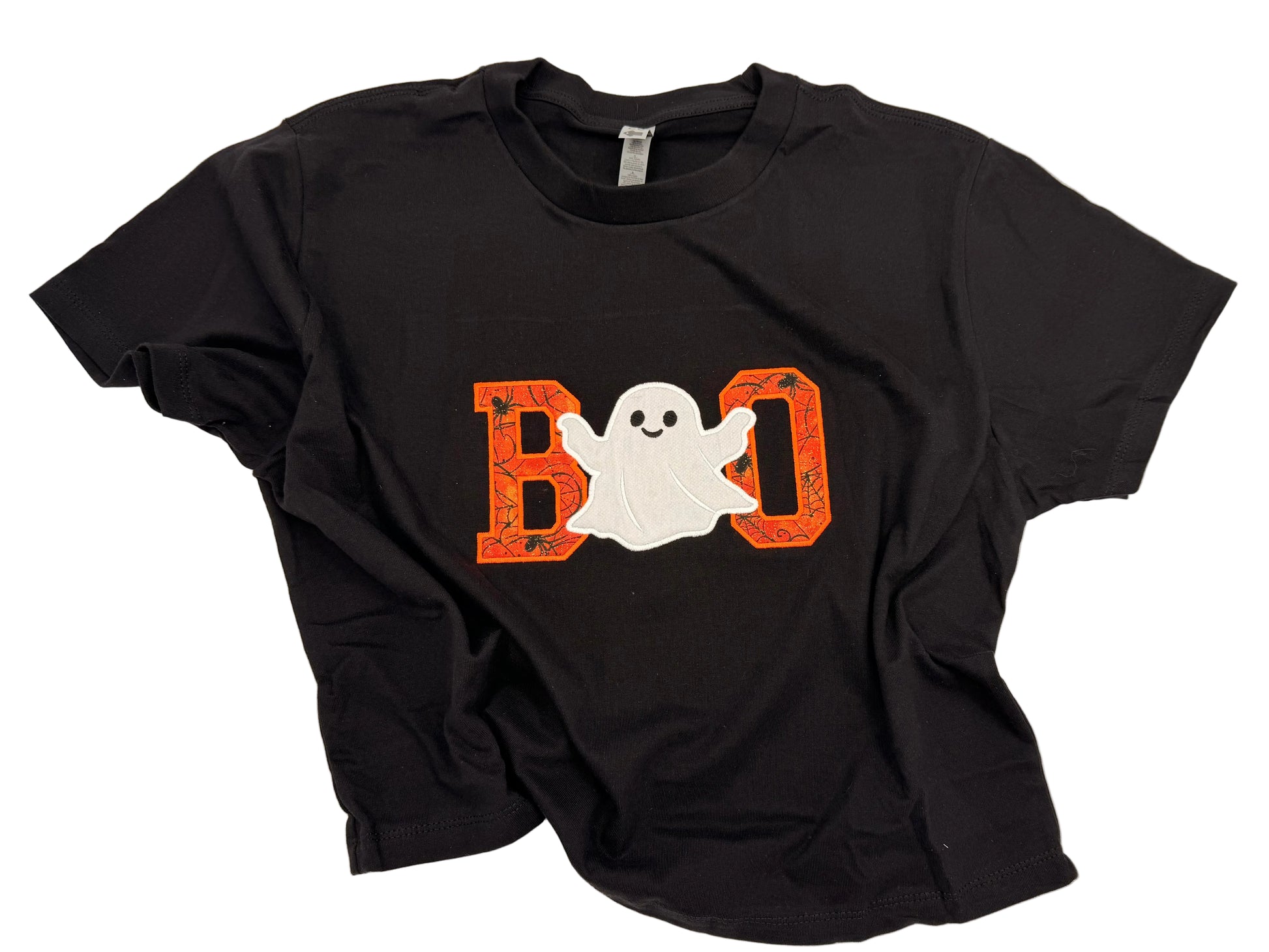 A black short-sleeve t-shirt laid flat on a white background, featuring a Halloween graphic on the front with the word 'BOO' in orange and a white ghost.
